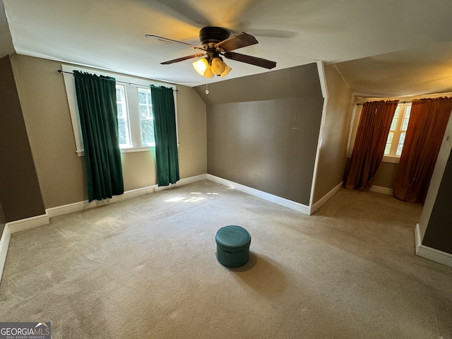 empty room with ceiling fan, light colored carpet, and lofted ceiling