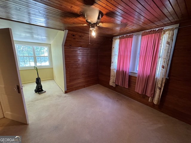 interior space featuring ceiling fan, carpet floors, lofted ceiling, wooden walls, and wood ceiling