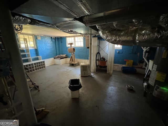 basement featuring brick wall and gas water heater