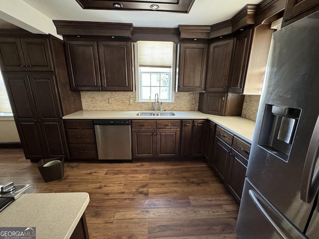 kitchen with dark hardwood / wood-style flooring, tasteful backsplash, dark brown cabinets, stainless steel appliances, and sink