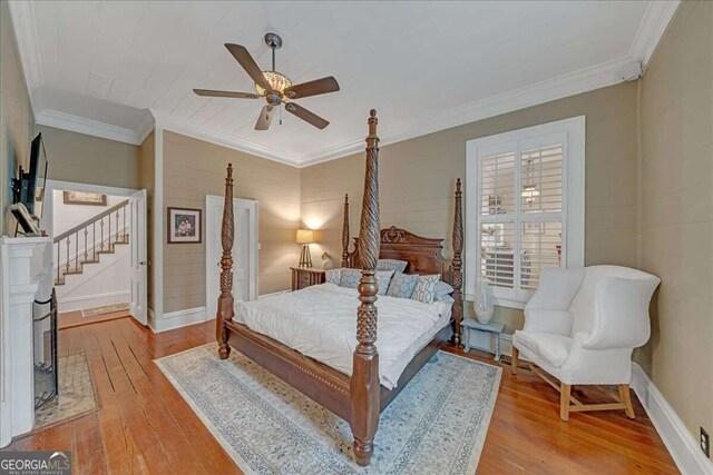 bedroom with light wood-type flooring, ceiling fan, and ornamental molding