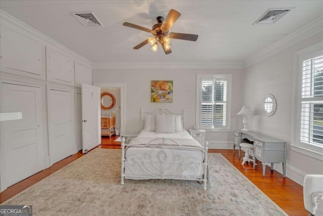 bedroom featuring ceiling fan, a closet, ornamental molding, and light hardwood / wood-style flooring