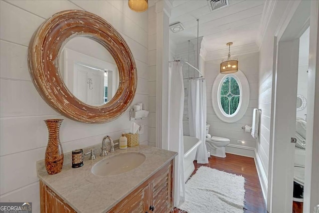 bathroom featuring ornamental molding, vanity, hardwood / wood-style floors, toilet, and wood walls