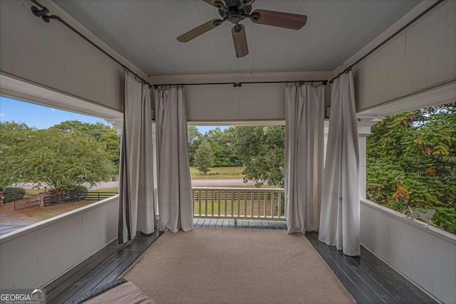 unfurnished sunroom featuring ceiling fan