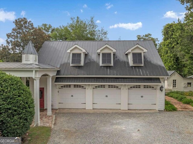 view of front of home featuring driveway and metal roof