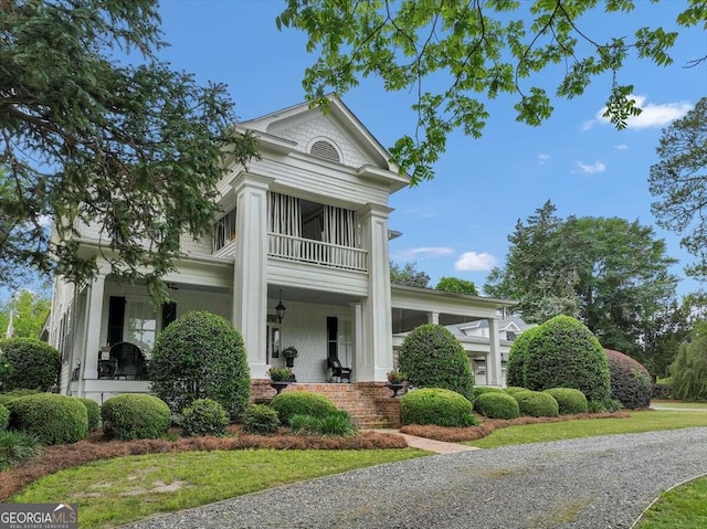greek revival inspired property featuring a porch