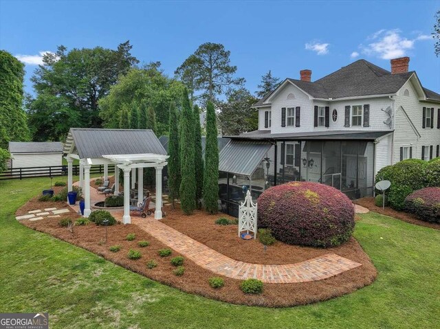 exterior space with a front lawn, fence, a chimney, a sunroom, and a pergola