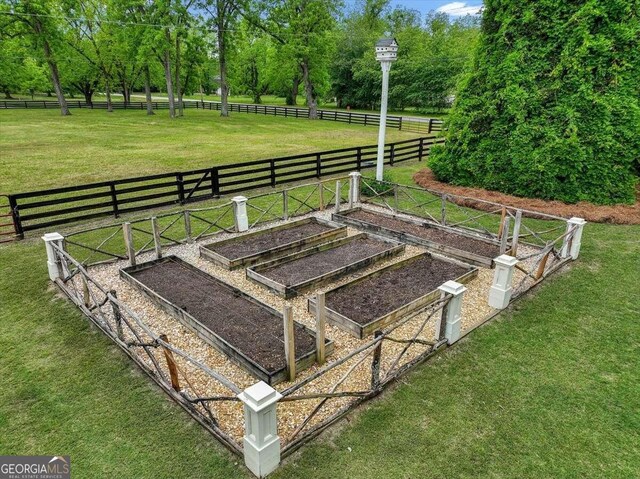 exterior space featuring a garden, a yard, a rural view, and fence