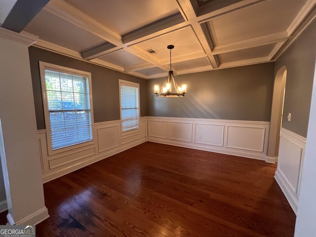 unfurnished dining area featuring beam ceiling, a chandelier, coffered ceiling, and ornamental molding