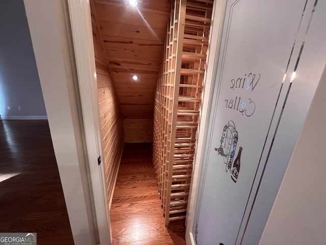 hall with wooden ceiling, dark wood-type flooring, and wooden walls