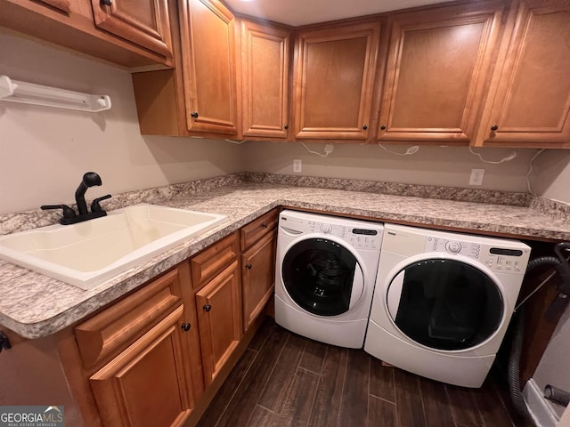 washroom with cabinets, washer and dryer, and sink