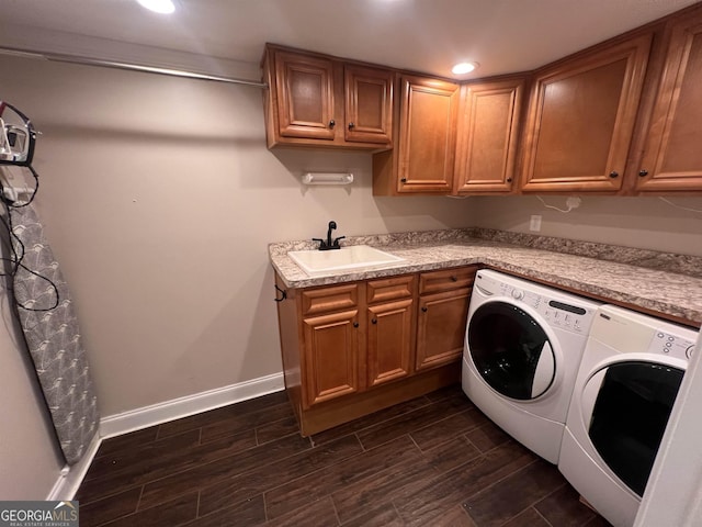 clothes washing area with washer and dryer, sink, and cabinets