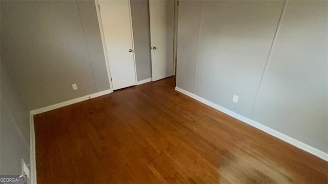 unfurnished bedroom with dark wood-type flooring