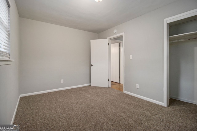 unfurnished bedroom with light colored carpet and a closet