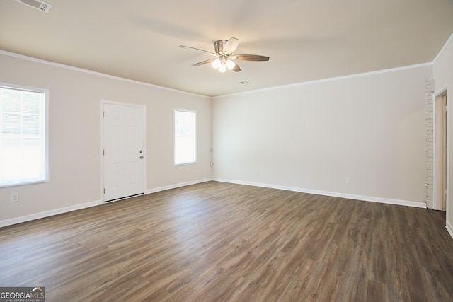 unfurnished room featuring a healthy amount of sunlight, dark hardwood / wood-style flooring, and ornamental molding