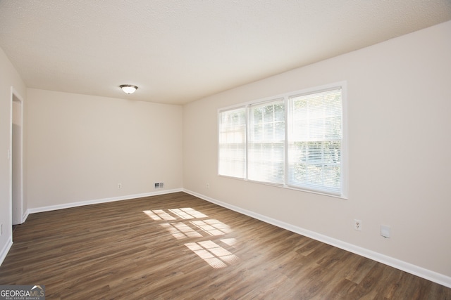 unfurnished room with dark wood-type flooring