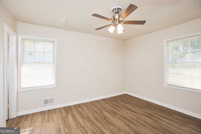 spare room with ceiling fan, wood-type flooring, and a textured ceiling