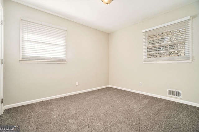 carpeted spare room featuring a healthy amount of sunlight