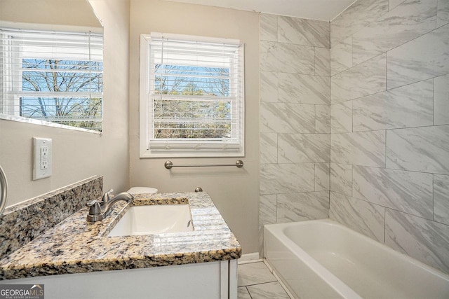 bathroom with vanity, a wealth of natural light, and tiled shower / bath combo