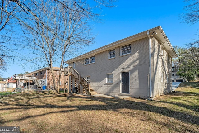 rear view of property featuring a yard and central AC