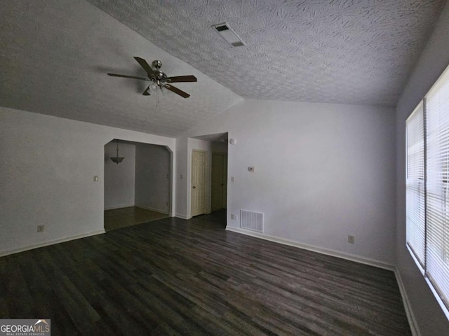 spare room featuring vaulted ceiling, ceiling fan, dark wood-type flooring, and a textured ceiling