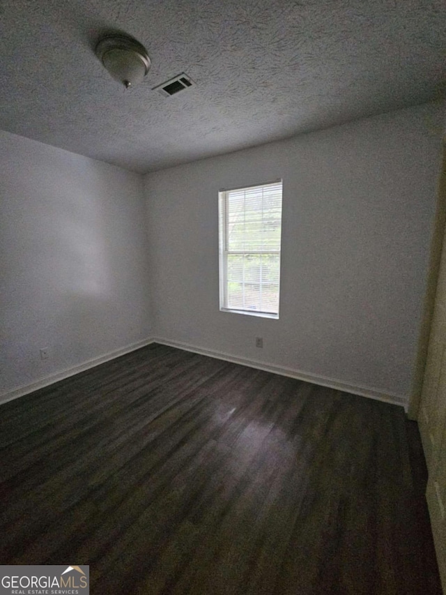 spare room featuring dark hardwood / wood-style flooring