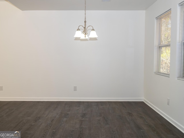 unfurnished room with dark wood-type flooring and a chandelier