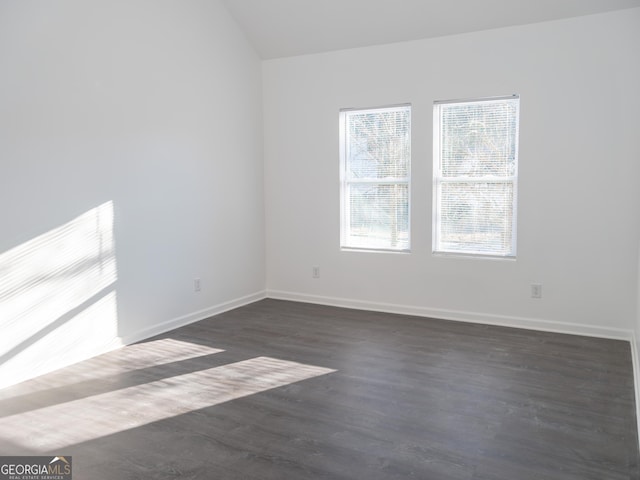 empty room featuring dark hardwood / wood-style flooring and lofted ceiling