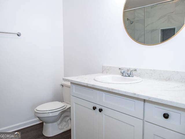 bathroom with hardwood / wood-style floors, vanity, toilet, and walk in shower