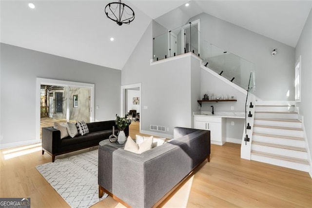 living room featuring light hardwood / wood-style floors and high vaulted ceiling