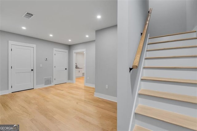 staircase with hardwood / wood-style flooring