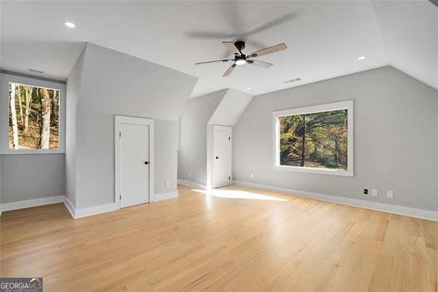 bonus room with lofted ceiling, light hardwood / wood-style flooring, and a healthy amount of sunlight