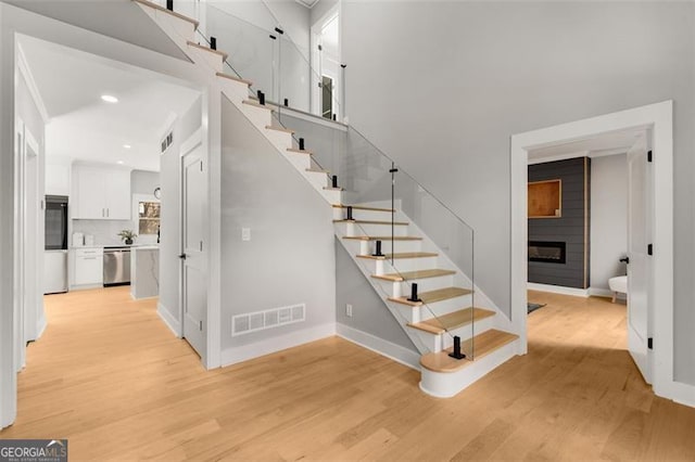 staircase featuring a fireplace and hardwood / wood-style floors