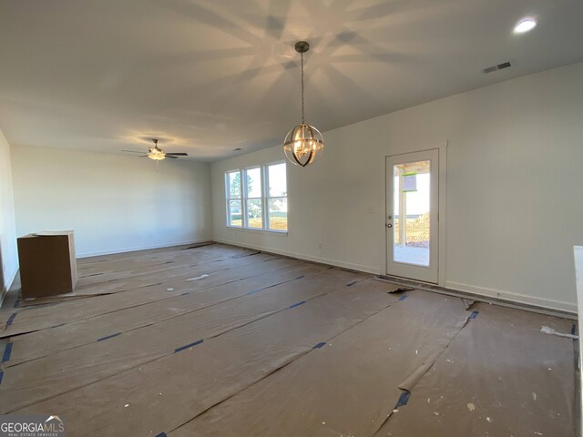 unfurnished dining area featuring ceiling fan with notable chandelier