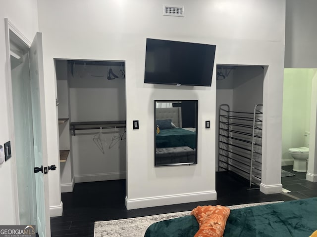 bedroom featuring dark hardwood / wood-style flooring and ensuite bath