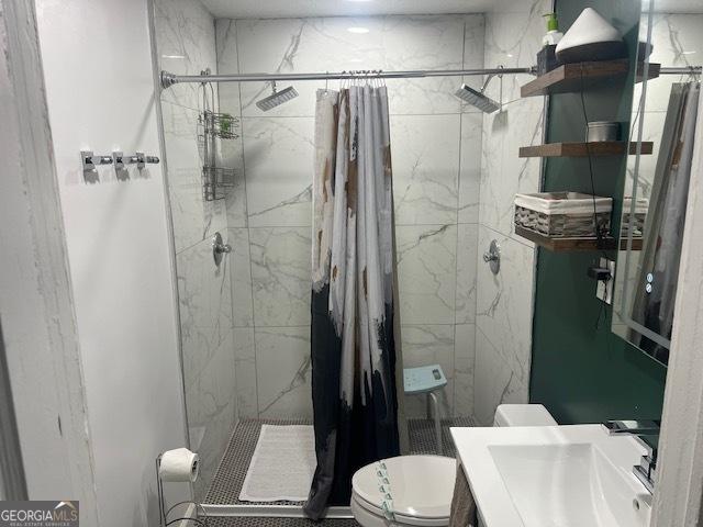 bathroom with a shower with shower curtain, vanity, and toilet