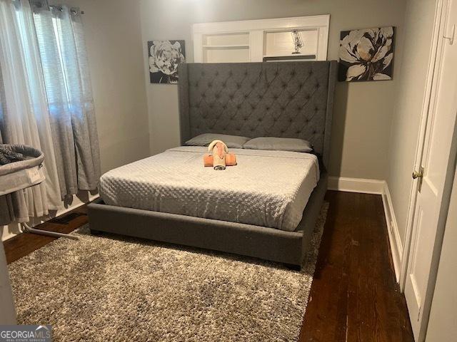 bedroom with dark hardwood / wood-style flooring