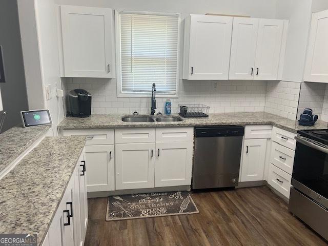 kitchen featuring tasteful backsplash, stainless steel appliances, sink, white cabinets, and dark hardwood / wood-style floors