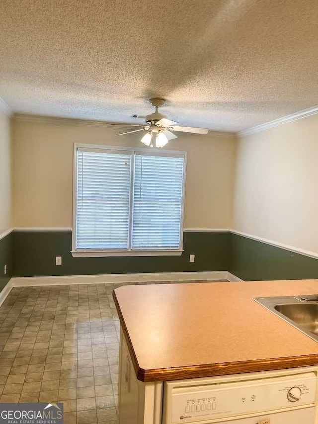 kitchen featuring white dishwasher, ceiling fan, ornamental molding, and a textured ceiling