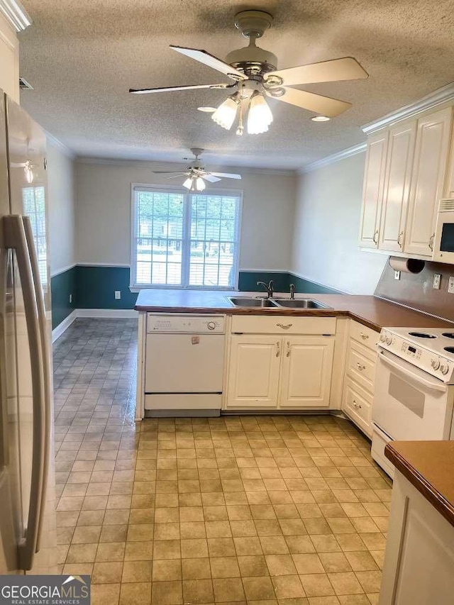 kitchen featuring kitchen peninsula, sink, white cabinets, and white appliances