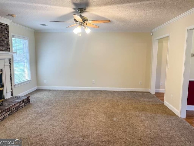 unfurnished living room with a brick fireplace, carpet, a textured ceiling, and ornamental molding