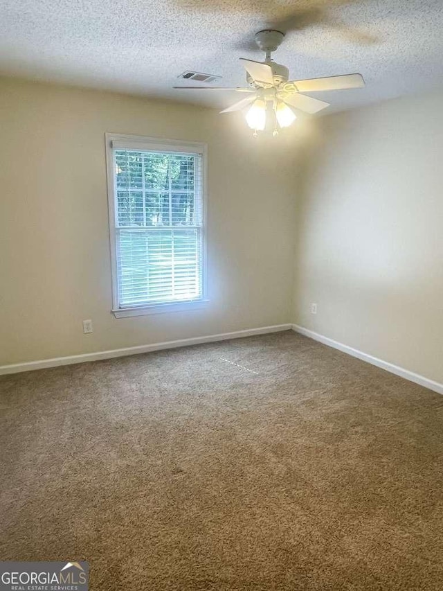 carpeted spare room with a textured ceiling and ceiling fan