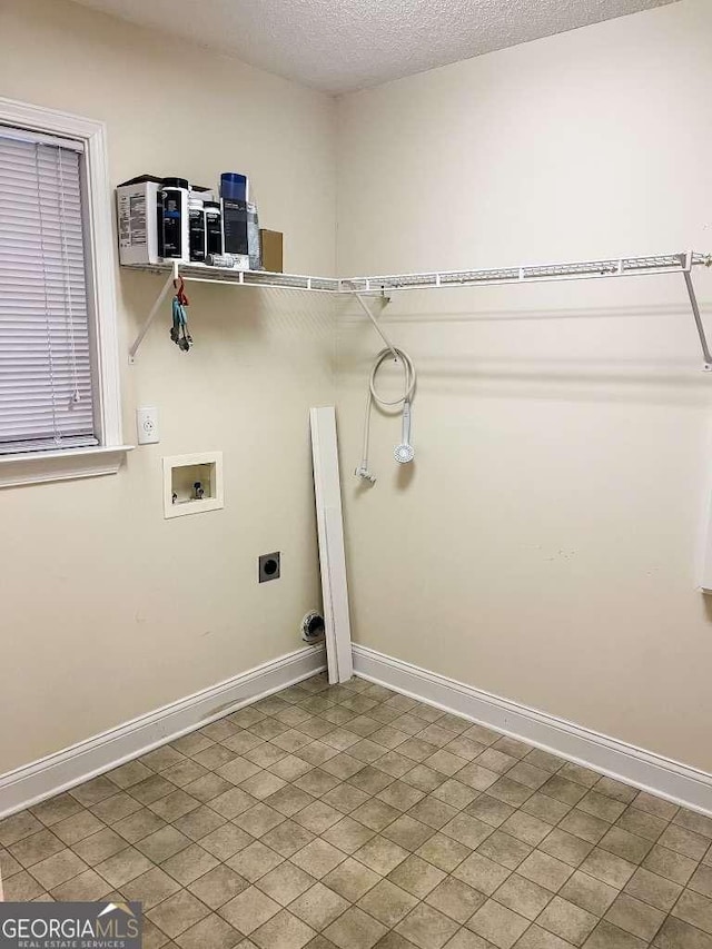 washroom with hookup for an electric dryer, washer hookup, and a textured ceiling