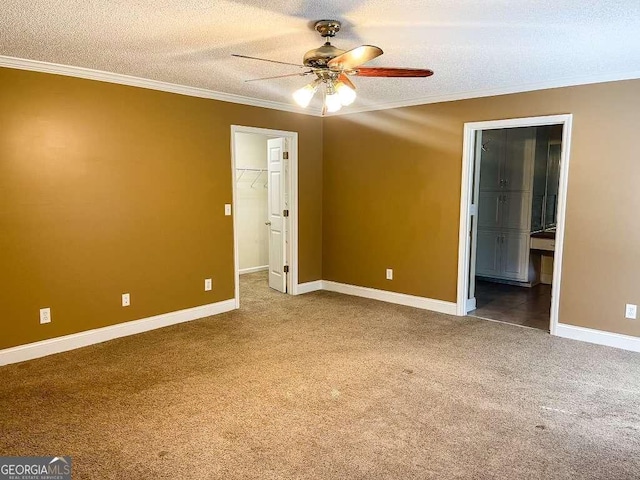 carpeted empty room featuring ceiling fan, a textured ceiling, and ornamental molding