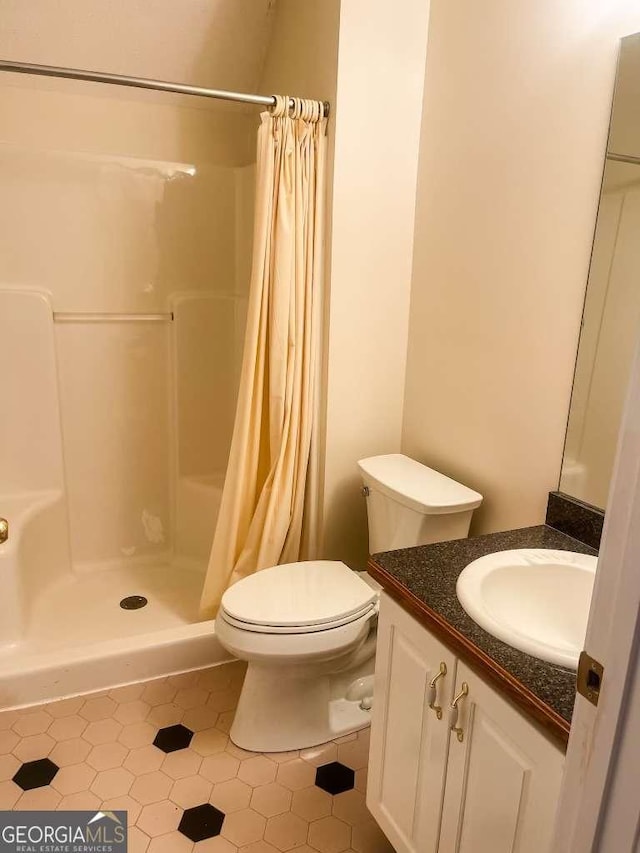 bathroom with curtained shower, tile patterned flooring, vanity, and toilet