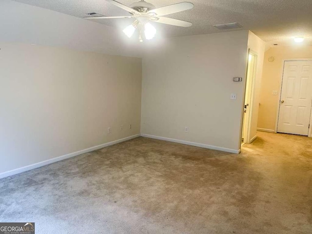 empty room with light carpet, a textured ceiling, and ceiling fan