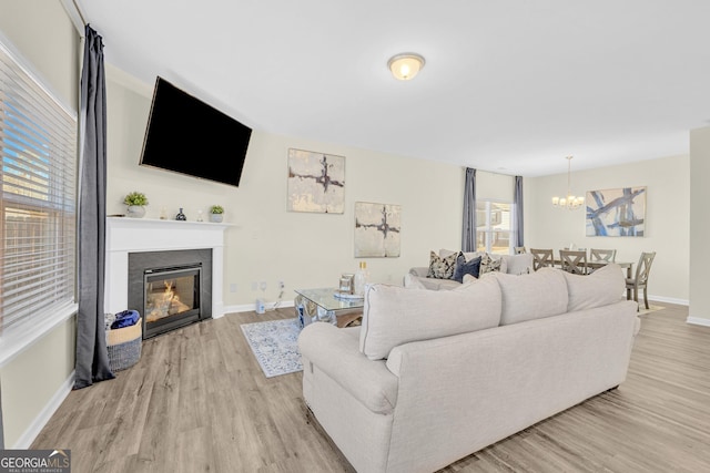 living room featuring a notable chandelier and light wood-type flooring