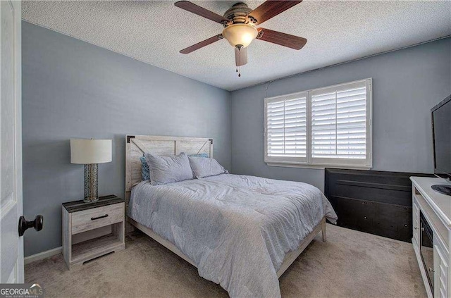 carpeted bedroom featuring a textured ceiling and ceiling fan