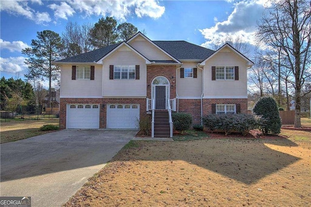 bi-level home featuring a garage and a front lawn