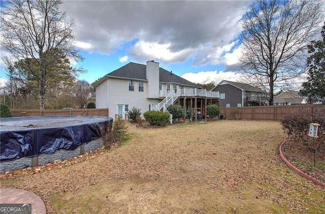 back of house with a swimming pool side deck and a yard